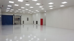 grande salle blanche avec porte rouge construite par Rosin Entreprise