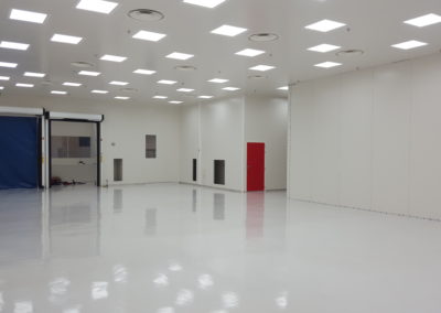grande salle blanche avec une porte rouge construite par Rosin Entreprise