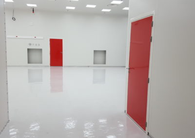 portes rouges dans une salle blanche par Rosin Entreprise