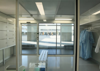 vestiaire avec des combinaisons stériles, des casiers et des fenêtres par Rosin Entreprise